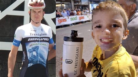 bambino felice che riceve una borraccia da un ciclista
