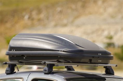 Immagine di un'auto con un box da tetto carico di bagagli durante una vacanza estiva