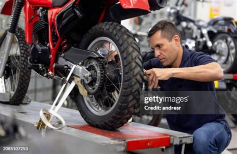 Manutentore che installa un portapacchi su una motocicletta.