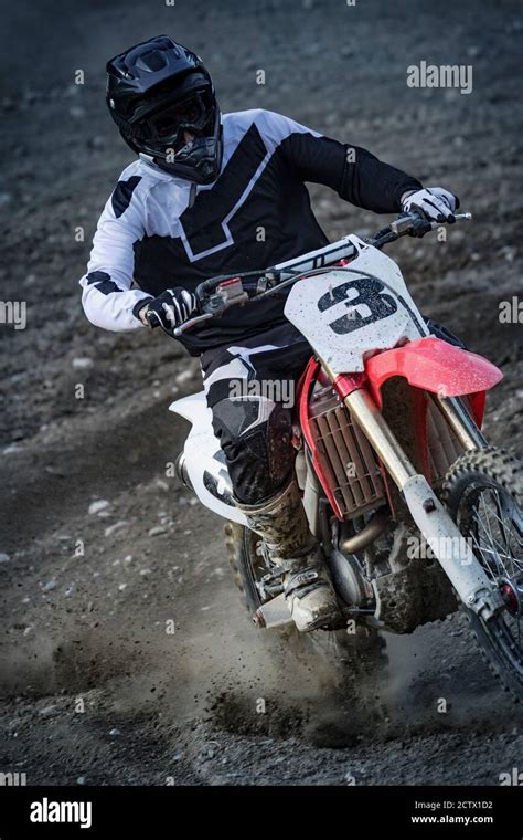 Pilota di motocross in azione su una pista sterrata