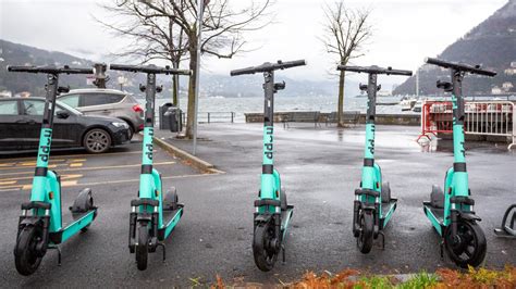 Monopattini elettrici a tre ruote parcheggiati in una zona dedicata