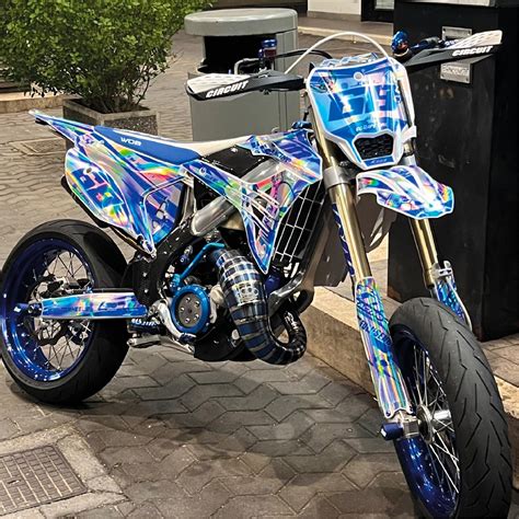 Immagine di una moto da cross con grafiche personalizzate e tabelle portanumero in tinta