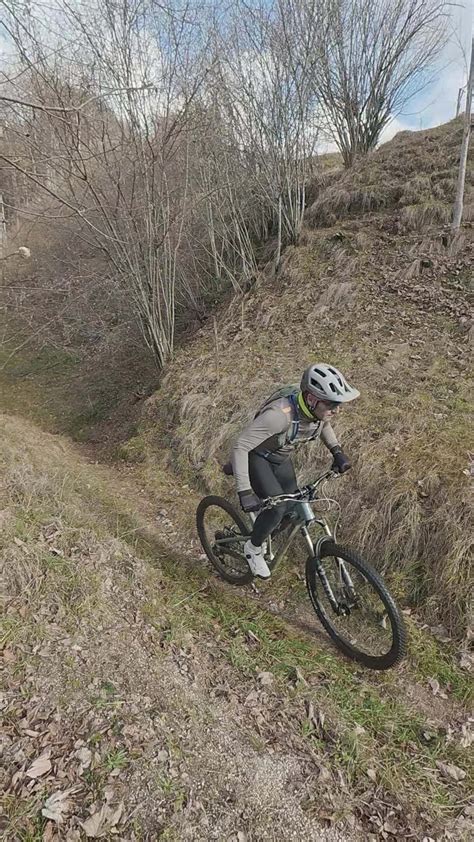 Ciclista in azione su un sentiero sterrato di montagna, con enfasi sulla trasmissione della bicicletta