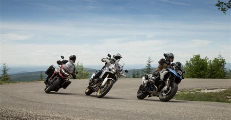 Motociclisti su moto enduro stradali in un paesaggio montano