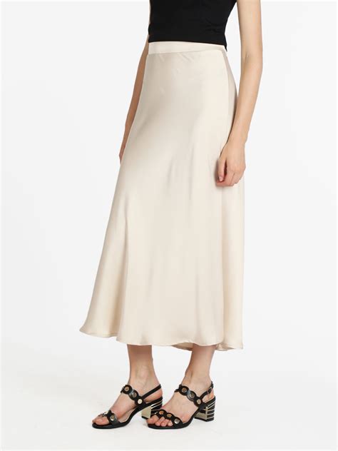 Donna che indossa una gonna lunga di seta fluida con un top elegante