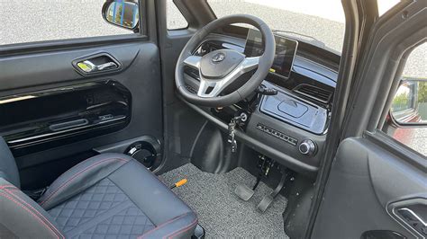 Interno di uno scooter elettrico cabinato con cruscotto digitale e sedile confortevole