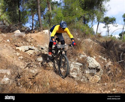 Ciclista in mountain bike da enduro su un ripido sentiero roccioso