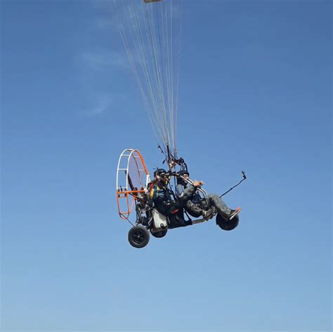 Pilota di paramotore che prepara l'attrezzatura con un passeggero