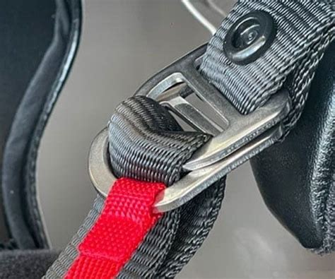 Primo piano di un sistema di chiusura a doppio anello a D su un casco