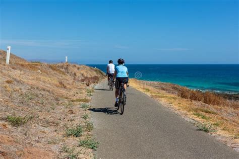 Ciclisti che pedalano lungo un lungomare panoramico