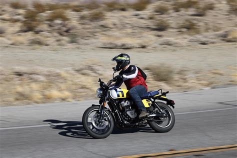 Un gruppo di giovani musicisti che suona davanti a una moto Scrambler