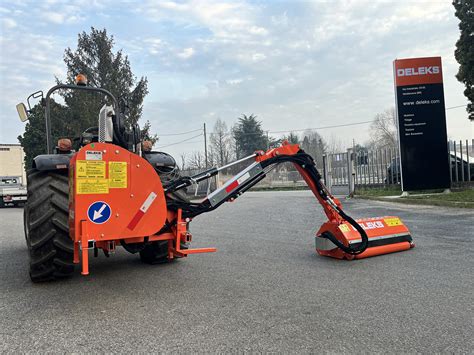 Trincia argini Deleks con braccio idraulico in azione su un argine