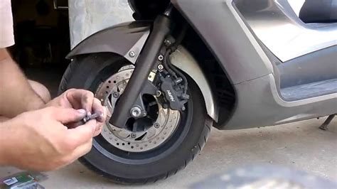Dettaglio del freno a disco anteriore e posteriore dello scooter Kymco