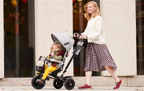 Bambino seduto in un passeggino triciclo in modalità passeggino con poggiapiedi.