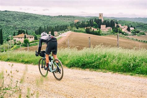 Ciclista su una gravel bike che attraversa un paesaggio rurale