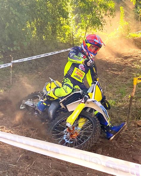 Pilota di motocross che affronta una curva con appoggio